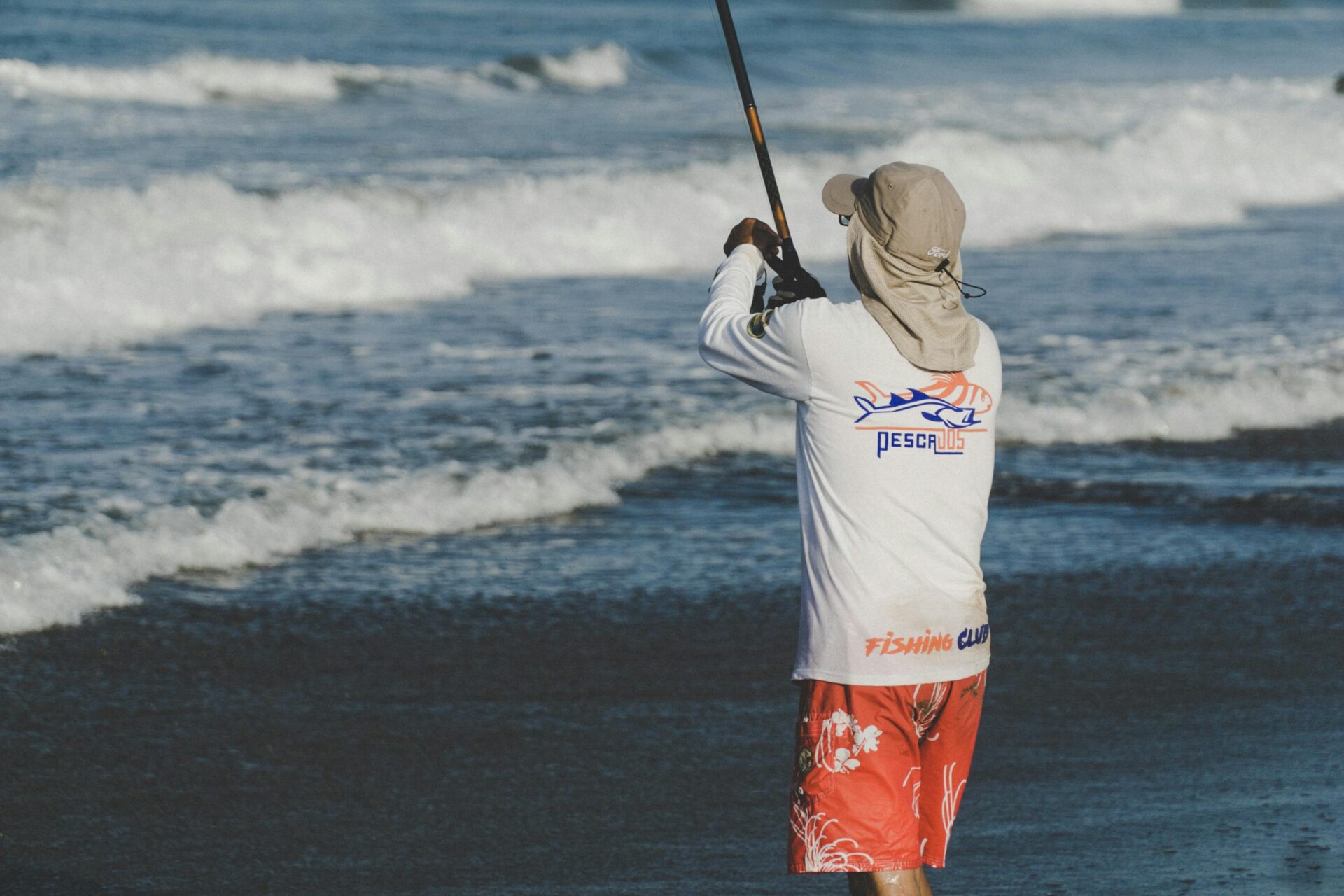 Fisherman casting rod on Altata beach in sunny weather, capturing the essence of coastal leisure.
