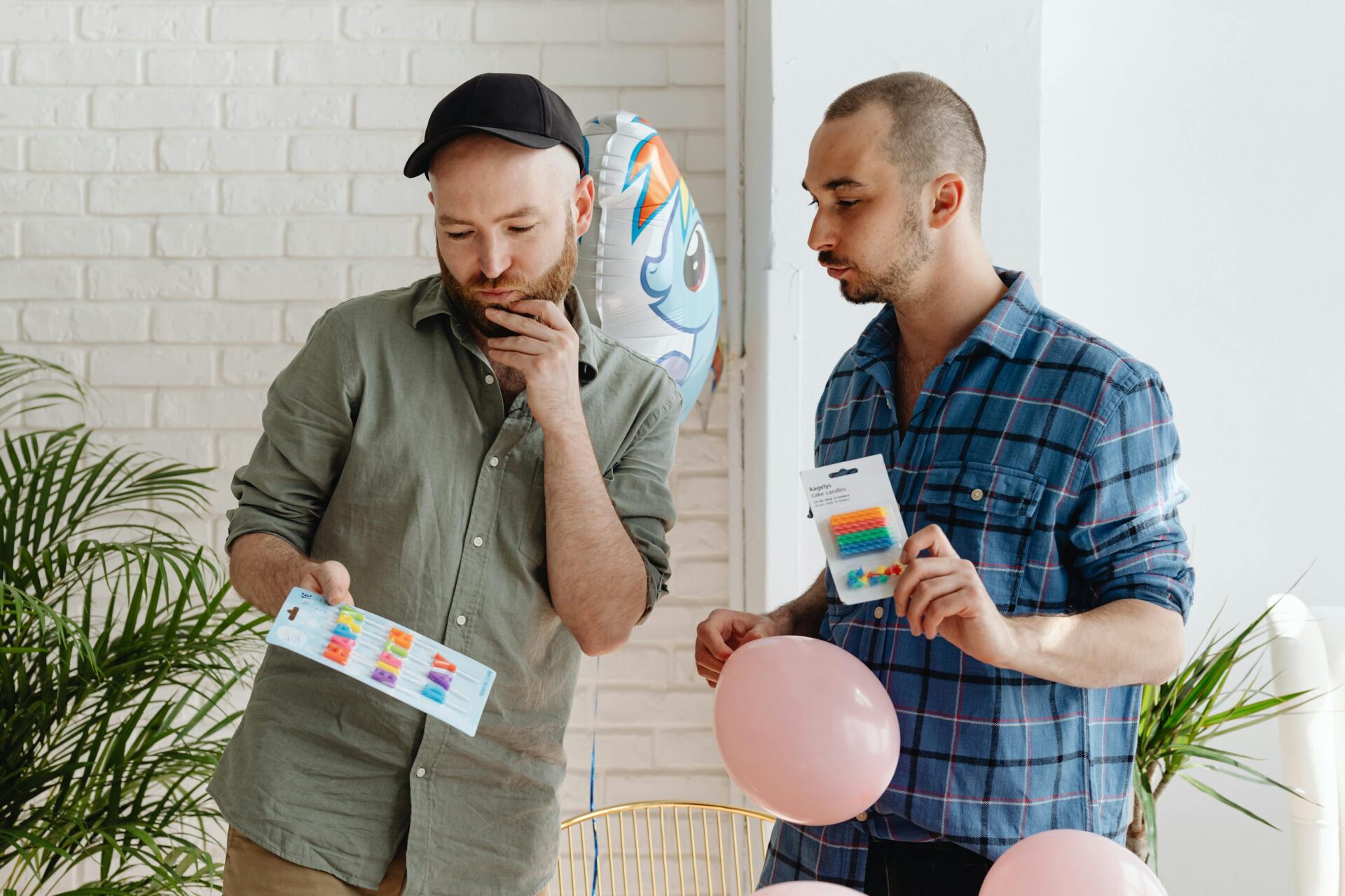 Two men decorate with balloons for an indoor birthday celebration. Bright and festive setting.